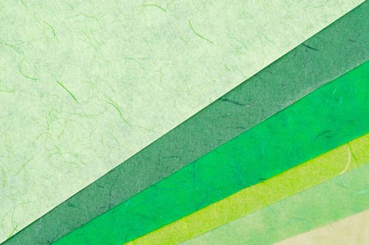 Color swatch of green paper texture made from recycled paper is used by designers to define the right colors for a project.