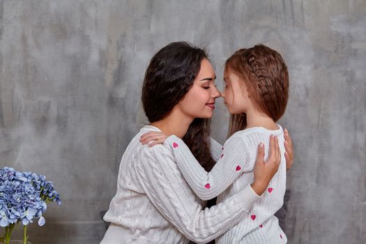 Emotions of a young beautiful mother and her little daughter who spend time together. They show love for each other