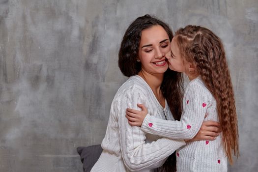 Emotions of a young beautiful mother and her little daughter who spend time together. They show love for each other