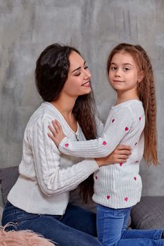 Emotions of a young beautiful mother and her little daughter who spend time together. They show love for each other