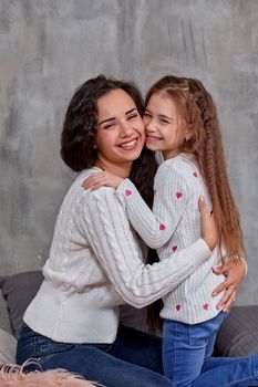 Emotions of a young beautiful mother and her little daughter who spend time together. They show love for each other