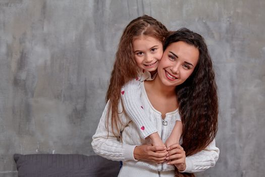 Emotions of a young beautiful mother and her little daughter who spend time together. They show love for each other