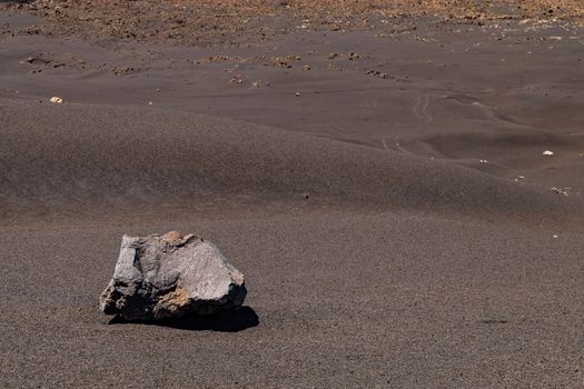 Slope with lava, ash and a large boulder at the volcano Pico do Fogo on the island Fogo, Cape Verde Islands