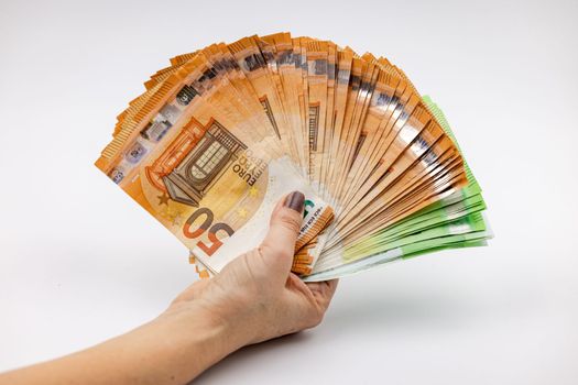A hand with a fan of 50 and 100 euro banknotes according to the motto no money, no fun