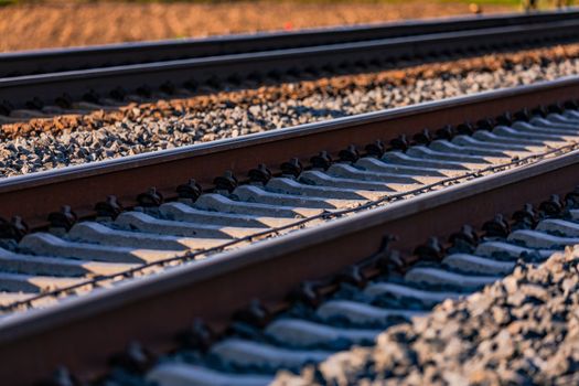 Sleepers and rails with screws in the track bed with ballast