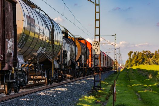 A freight train carrying goods and passing through a rural area, in autumn, Germany