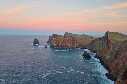 Beautiful picturesque sunset in Madeira island. View from above on the coast. The Atlantic Ocean washes the shores of the island of Madeira