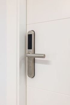 Door handle with plastic card with microchip or digital code. Closeup of an entrance white door with an electronic mortise lock