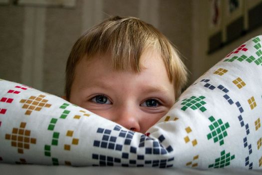 Close-up Of The Face Of A Beautiful 5 Year Old Boy Lying On The Bed. High quality photo