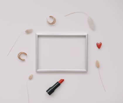 minimal fashion mockup with empty photo frame and red lipstick and women's accessories on white background. 