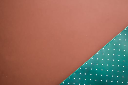 Abstract green polka dot background on brown backdrop.