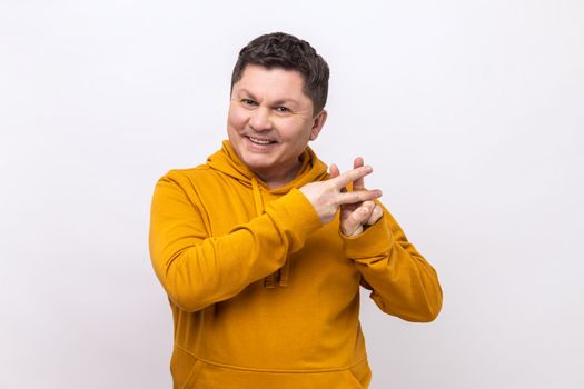 Viral internet topic. Cheerful man smiling joyfully and showing hashtag gesture, hash symbol of message in social media, wearing urban style hoodie. Indoor studio shot isolated on white background.