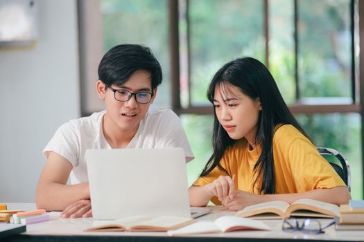 Young woman and man studying for a test or an exam. Tutor book with friends. Young students campus or classmates helps friend catching up workbook and learning tutoring in classroom, teaching, learning