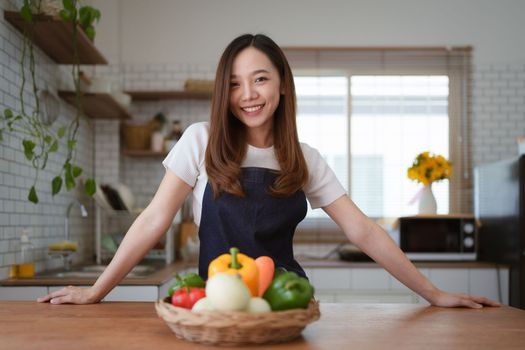 Portrait of beautiful young asian woman making salad at home. cooking food and Lifestyle moment.