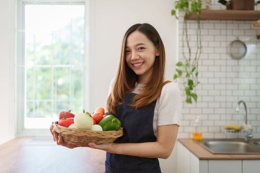 Portrait of beautiful young asian woman making salad at home. cooking food and Lifestyle moment.