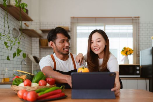 Portrait of young asian couple making salad together at home. cooking food and Lifestyle moment and healthy.
