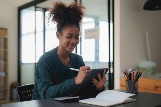 Young black curly hair American African woman using digital tablet.