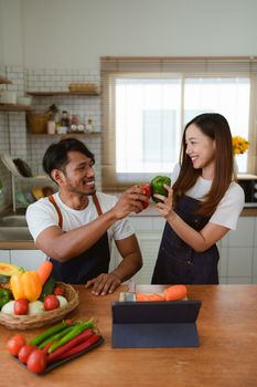 Portrait of young asian couple making salad together at home. cooking food and Lifestyle moment and healthy.