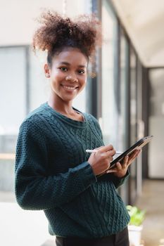 Young black curly hair American African woman using digital tablet.