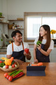 Portrait of young asian couple making salad together at home. cooking food and Lifestyle moment and healthy.