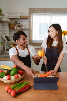 Portrait of young asian couple making salad together at home. cooking food and Lifestyle moment and healthy.