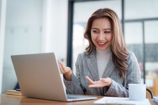 Portrait of Smiling asian business woman with laptop computer in office. Woman in suit at office.