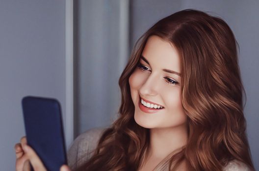 Beautiful woman having a video call and talking on mobile phone, girl doing online shopping on smartphone.