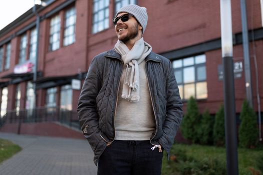 stylish man in sunglasses and hat outside.