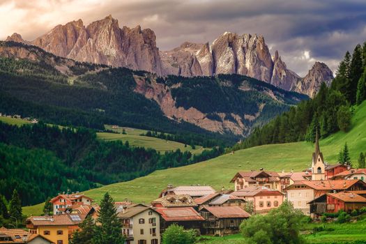Langkofel and alpine village, Sassolungo pinnacles, Dolomites sudtirol, Pordoi Pass near Cortina d Ampezzo, Italy