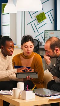 Black Businesswomen shaking hands with manager sitting on couch during business meeting. Diverse business people planning partnership deal discussing project steps for new start-up company.