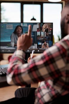 Office worker using online videocall meeting with employees on computer, talking on remote teleconference with webcam. Freelancer attending conference call on internet, teleconference at home.