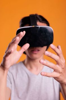 Gamer wearing vr headset playing virtual reality games, exploring metaverse close view, focus on hands. Person in ar goggles enjoying simulation experience, cyberspace entertainment