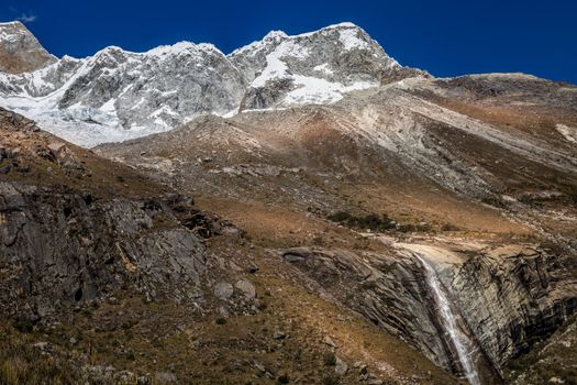 Waterfall and Huascaran Mountain massif in Cordillera Blanca, snowcapped Andes, Ancash, Peru, South America