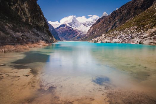 Turquoise Paron laguna in Cordillera Blanca at sunny day, snowcapped Andes, Ancash, Peru