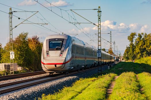 An ICE on a rail track in rural Germany is powered by electricity