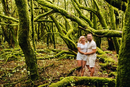 Two people, a man and a woman in white clothes, are standing in an old forest on the island of LA Gomera. The Canary Islands. Spain.