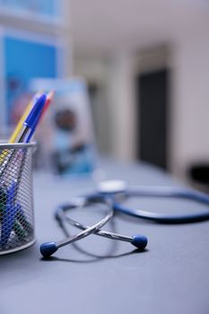 Medical equipment unused by anyone on empty table with hospital items. Medical items on reception desk with no general practitioner using them to check sick patients. Stethoscope on counter in hospital.