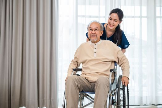 Happy curator person doctor pushing wheelchair and run elderly disabled patient freedom raising arm at hospital, senior retired man sitting on wheelchair having fun with young woman nurse, health care