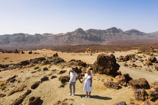 A married couple is standing in the crater of the Teide volcano. Desert landscape in Tenerife. Teide National Park. Tenerife, Spain.