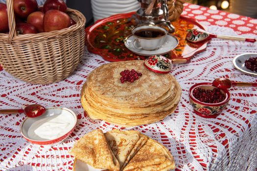 Pancakes with berries and sour cream on the table. Shrovetide Maslenitsa festival concept.
