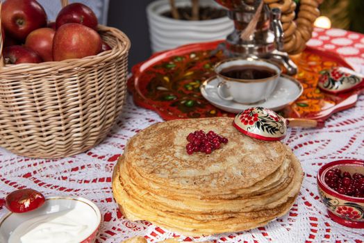 Pancakes with berries and sour cream on the table. Shrovetide Maslenitsa festival concept.