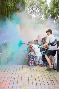 Lviv, Ukraine - July 18, 2021: Color Holi Festival, a crowd of people adults and small children throw colorful paint. Indian holiday