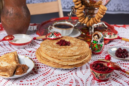 Pancakes with berries and sour cream on the table. Shrovetide Maslenitsa festival concept.