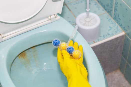 A yellow-blue plastic toilet block that cleans the walls of the toilet and refreshes the bathroom