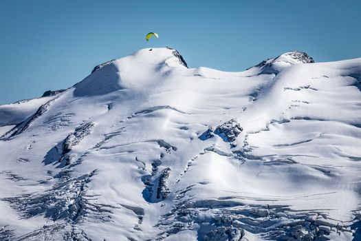 Paragliding above Bernina and Palu mountain range with glaciers in the Swiss Alps, Engadine, Switzerland