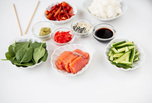 Sushi preparation process, preparation of all ingredients for sushi rice, salmon, pepper, sesame seeds, sauce, wasabi, ginger. View from above