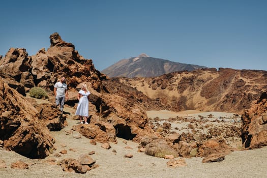 A married couple is standing in the crater of the Teide volcano. Desert landscape in Tenerife. Teide National Park. Tenerife, Spain.