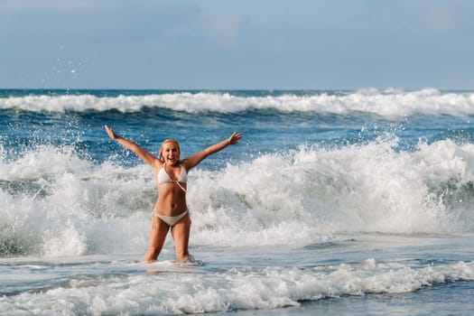 A girl with wet hair happily swims on the waves in the Atlantic Ocean.Tenerife.Spain.