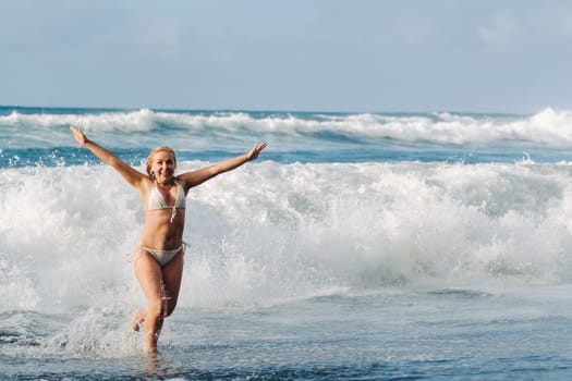 A girl with wet hair happily swims on the waves in the Atlantic Ocean.Tenerife.Spain.