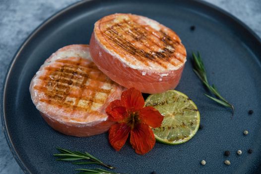 Grilled salmon roll with mozzarella. Decorated with greens lime and edible flower